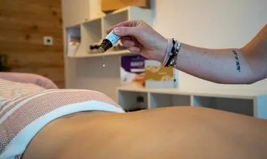 ätherisches Öl tropft auf den Rücken für eine Aroma Klang Anwendung
